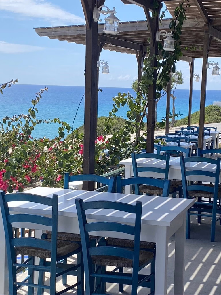 Blaue Stühle Mit Weißen Tischen, Im Hintergrund Das Meer